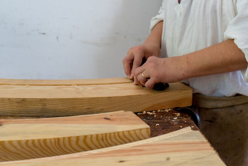 Woodworker meticulously crafting bespoke furniture in a workshop